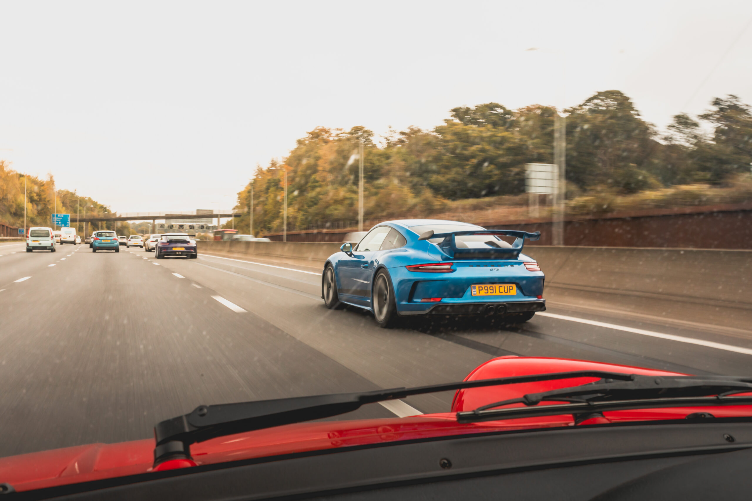 blue porsche driving on the motorway